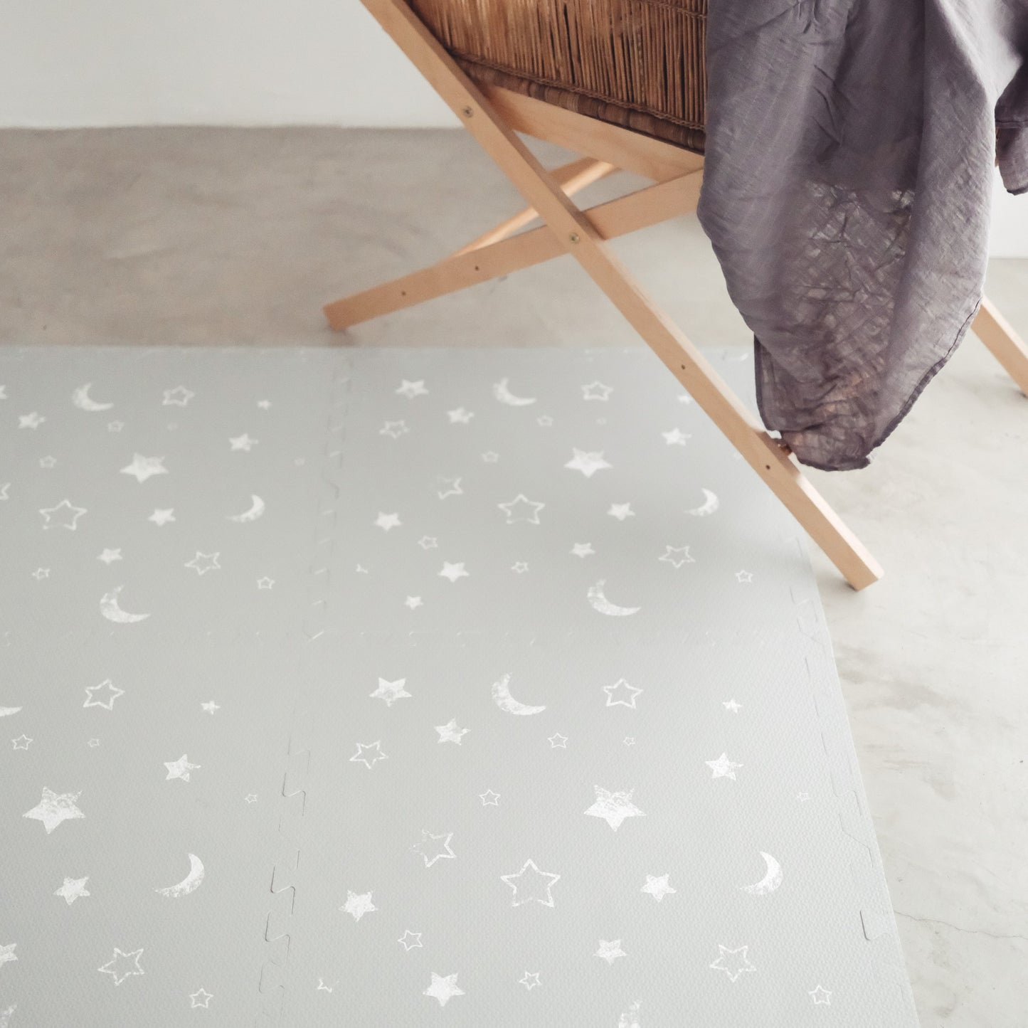 Faded stars and moons on grey play mat